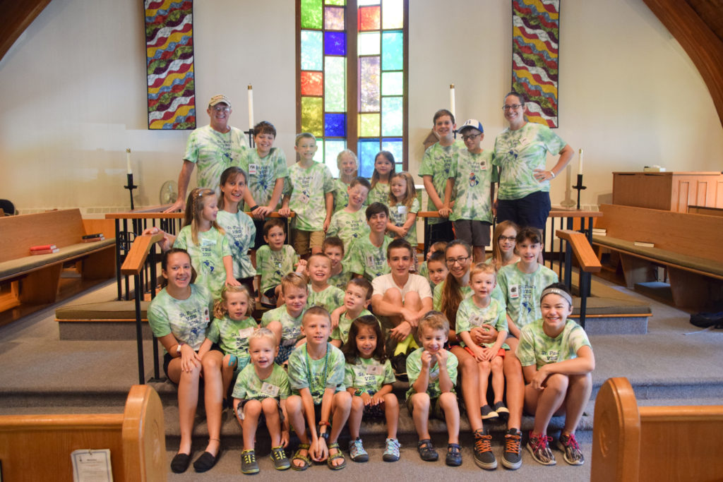 Group shot of vacation bible school attendees, in matching tie-dyed tee shirts, in St. Paul's sanctuary.
