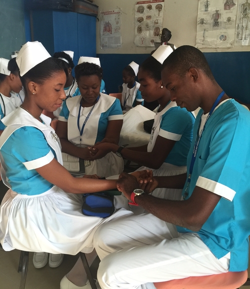 Haitian nursing students checking pulse.